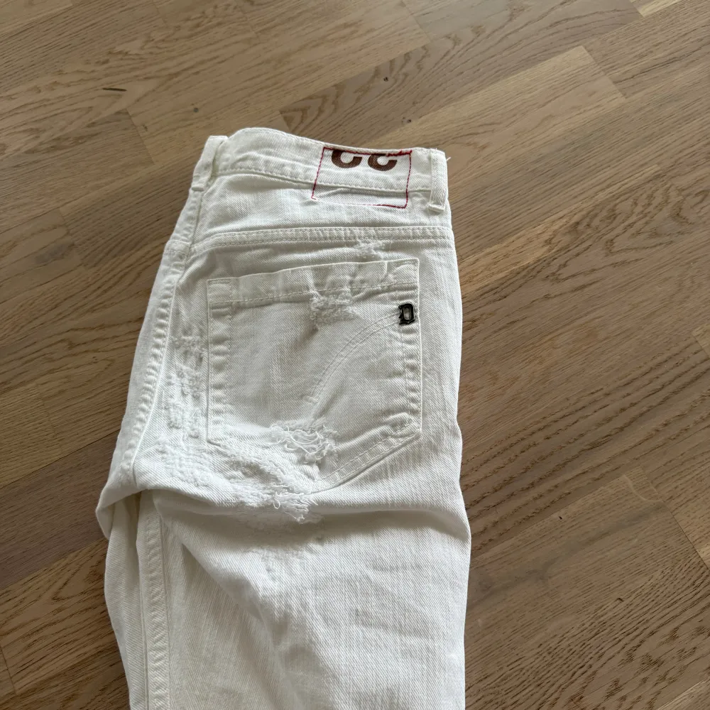 Säljer nu dessa Vita Dondup jeans med massvis med slitningar! Jeans modellen är George och är slimfit. . Jeans & Byxor.