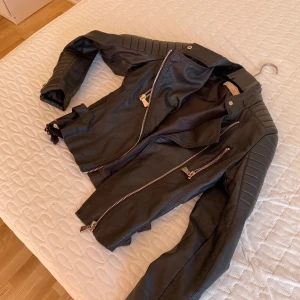 Svart skinn jacka  - Säljer denna skinnjacka som är använd. Köpte för 800/900kr på Nelly. Har skada så därav priset säljer för 250kr. Storleken är 38/M och kan passa en 36a också. Kontakta för mer bilder o info❤️