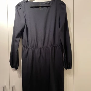 Nätt svart klänning  - Knälång, resor baktill gör det till en markering i midjan, lätt tunn snygg både till vardags som fest. 