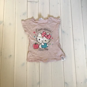 HelloKitty tröja  - Hello Kitty tröja för 6år, köpt på en secondhandbutik och aldrig använts efter det! Har en pytteliten fläck på ryggen. Kollationering bio för mer info!
