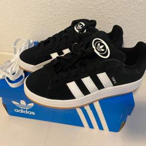 Adidas Originals Campus 00 s j 37 1/3. Svart. Core Black / Cloud White / Cloud White. Ingår både vita och svarta skosnören. Nya och oanvända. Kommer ej från någon massbeställning från utomlands. Köpta här i Sverige och därmed garanterat äkta.