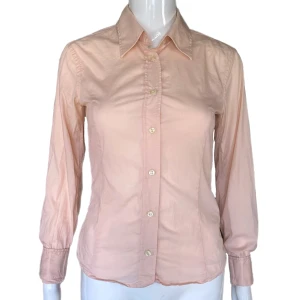 Tiger Of Sweden Skjorta  - Tiger Of Sweden långärmad skjorta i fint skick. Dockan använder 34 ⚠️ Svårt att få exakta färgen på bild! En slags rosfärg, som på första bilden! MÅTT: Axel till axel 36cm, Armhåla till armhåla 40cm, Ärmlängd 60cm & Längd (från armhåla och ner) 32cm 