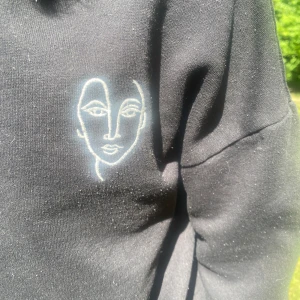 Svart hoodie med detalj - Mjuk hoodie som går att justera storleken på med snörning (se tredje bilden).