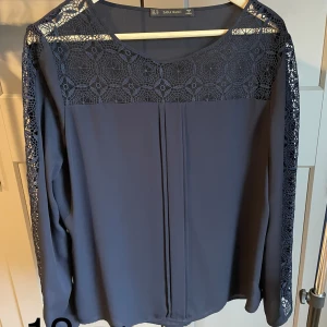 Marinblå blus - Blus från Zara med fina detaljer i spets. Liten i storleken. Passar en storlek L.
