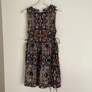 Sommarklänning - Använd men ändå i fint skick. Dragkedja i bak och snörning på båda sidorna. 