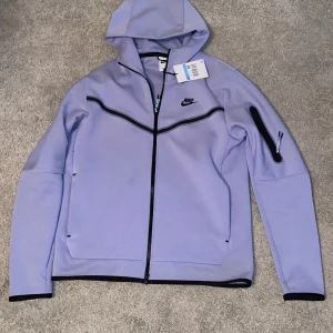 Tech fleece  - Tech Fleece i storlek M, lila färg – en stilfull och bekväm statement-piece. Perfekt för att höja din streetwear-stil. Sälj den som en unik möjlighet att vara trendig och samtidigt hålla sig varm.  Har använt den i ett år nu. 
