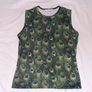 Linne med påfågelfjädrar♡ - Coolaste trycket på dethär linnet;) tyget är träningskläder-aktigt. Knappt använt.