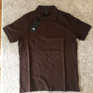 Pikétröja  - En snygg pikétröja, Helt ny aldrig använd.   • Helt ny • Färgen brun • storlek S