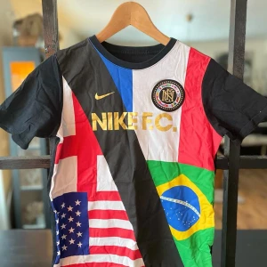 Nike Boys Swoosh Tee Flag World Cup  - En snygg T-shirt i nyskick i storlek 147-158 cm (12- 13 YRS) 