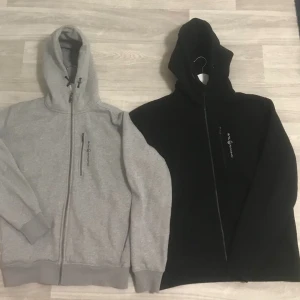 Sail Racing zip Hoodie (Nyskick) (Xl) - Hejsan,  Säljer två styckna Sail Racing Zip hoodie (Xl) i färgen svart och grå som endast är använda 1-2 gånger, båda är som nyskick. Säljes pågrund av att jag har för många klädder liggandes och detta var ett spontant köp.  Säljer båda för 900kr !!