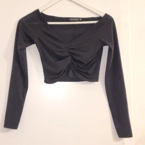 Topp - En fin svart topp från Pretty little thing. Den har fina detaljer mellan brösten och är långärmad. Använd ca:2 gånger och är i bra skick. Frakt ingår med 29kr. 