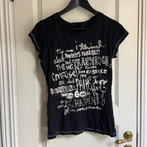 Svart t-shirt - Svart t-shirt med ett tryck på framsidan. T-shirten har en rund halsringning.