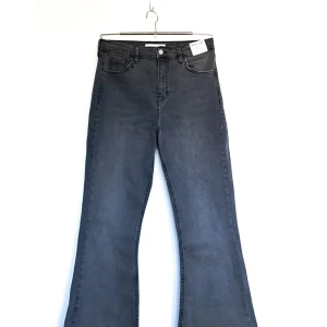 Flared jeans från Topshop - Mörkgrå utsvängda jeans från Topshop. Aldrig använda, lappen är kvar. (W30/L32)