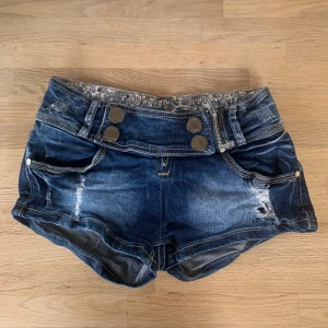 Minishorts  - Ett par mörkblåa, ”slitna” jeansshorts. Endast använda ett fåtal gånger av mig (köpta begagnat) och saknar defekter utöver lite röd färg i den vänstra framfickan. Vid frågor eller önskemål om fler bilder är det bara att skriva privat. 💕