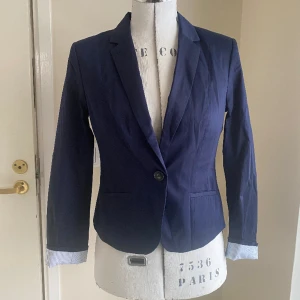 Kort kavaj, stl 38 - Lite kortare klassisk kavaj i mycket fint skick. Vet inte ens om jag någonsin använt den. Snyggt randigt foder som också syns på uppvikta armar.  Djur- och rökfritt hem. 