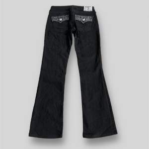 Svarta true religon jeans med stenar på fickorna i modellen Hi-Rise boot, fint skick inga tecken på defekter, tagg: storlek 26. Ytterbens längden är ca 94cm och midjan är ca 36cm rakt över, tveka inte på att kontakta vid minsta fundering!