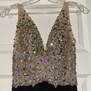 Balklänning från Jovani Fashions - Balklänning/festklänning från Jovani med dekorativa stenar på framsidan och öppen rygg. Inköpt på Dressroom Linne för 4500 kr. Endast använd en kväll. Nyskick och väldigt ren och fin. Strl 34. Kvitto finns. 