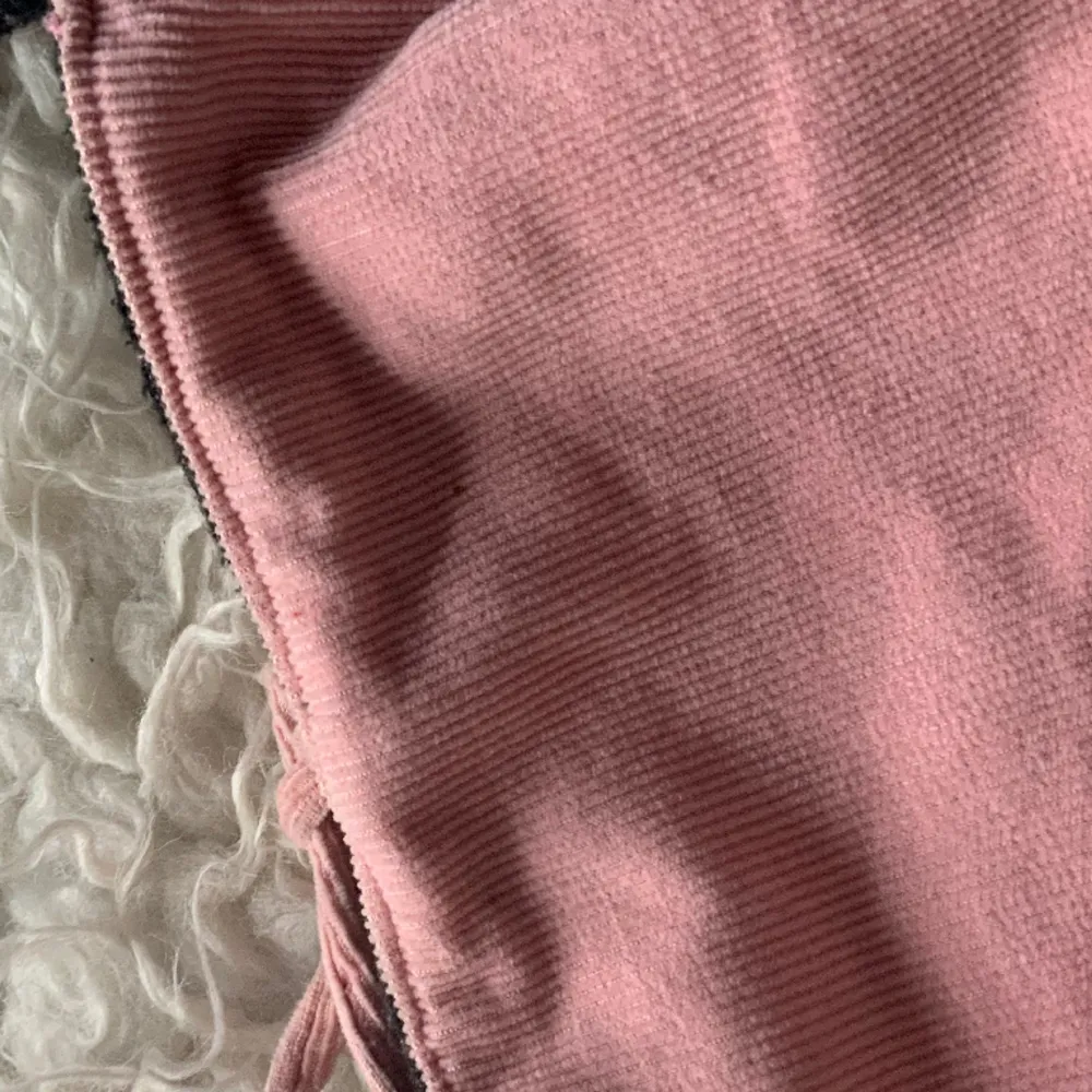 Söt rosa axelremsväska. Den har snören som kan knytas samt en ficka med dragkedja i. Bra skick förutom pytte liten defekt som visas på bild 2. Syns knappt. . Väskor.