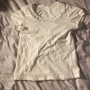 Vit bomulls t-shirt från kaffe - Säljer denna superfina topp från kaffe då den aldrig kommer till användning. Storlek S, passar nog även XS. Nyskick, använd fåtal gånger. Pris går att diskuteras och det är bara att höra av sig för fler bilder🫶
