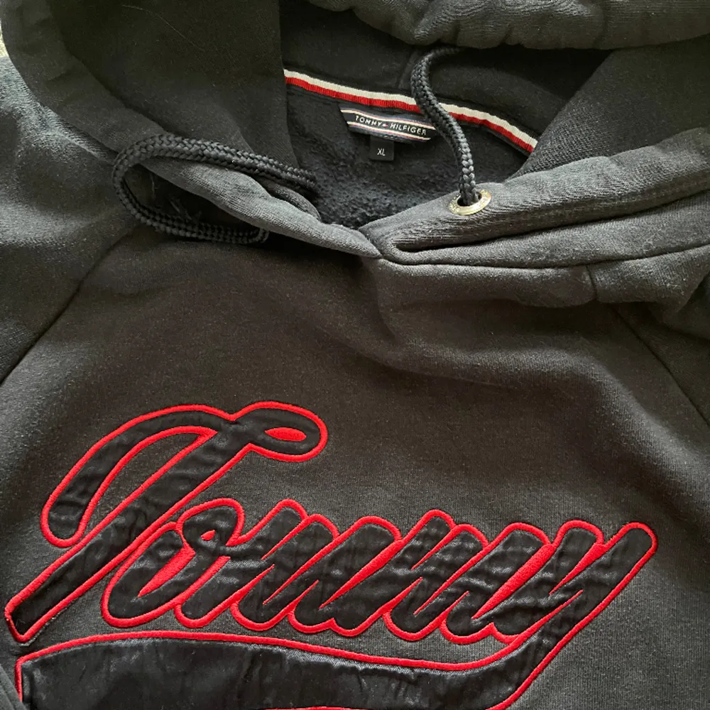 Fin mörk hoodie med röd text ”TOMMY”  Storlek XL 100:- exkl. frakt. Hoodies.