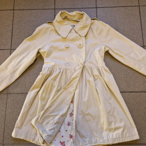 Blommig fodrad kappa - Går att ta bort kragen. Passar S/M/L gällande på hur man vill att den ska sitta. Väldigt fint skick Hällor i sidorna om man vill ha ett bälte på.