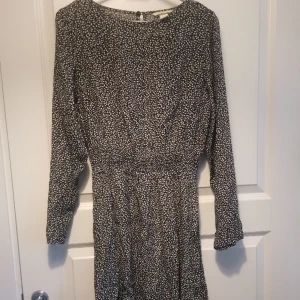 Söt klänning med små bladrankor - Vad trött jag blir.. Alla mina bilder har beskurits väldigt dåligt men skulle väl säga att denna klänningen är knälång i väldigt fint tunnt tyg och i fint skick. Öppning och knapp baktill