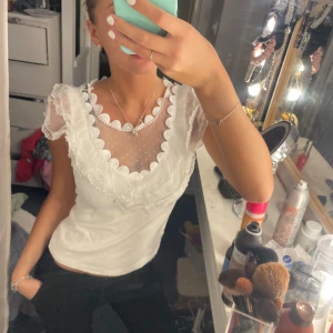 Vit topp med volanger i spets - Så fin. Använd en gång. Inga defekter. Storlek s. Jag brukar ha xs i kläder och denna Sitter så fint. 