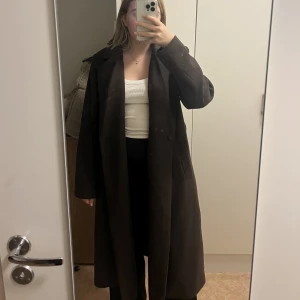 Brun kappa - Jättefin brun kappa från BikBok i storlek S. Går ner till vaderna på mig som är 168 cm! Inköpt för ca 800 och är fortfarande i väldigt fint skick då den knappt har använts 🤎