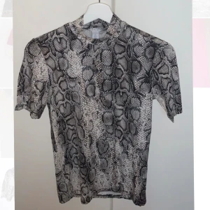 Elegant t-stirt med ormskinnsmönster  - Väldigt elegant t-shirt med ormskinnsmönster, passar XS och S. Mycket bra skick
