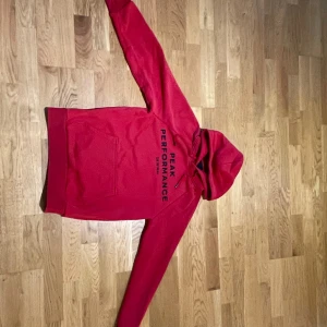 Röd Peak Performance Hoodie - En snygg röd Peak Hoodie i storlek S, Bra skick, Priset ej hugget i sten, Våga ställa frågor i pm!