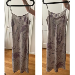 långklänning weekday - jättefin långklänning från weekday! justerbara band, slits på sidan, superfint mönster! har några slitningar på sömmen på sidan där det suttit säkerhetsnålar (sista bilden) men syns inte alls när man har på sig den, annars knappt använd