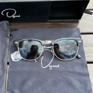 Dupond Shades Solglasögon, Helt nya - De svarta solglasögonen från Dupond är en perfekt kombination av trend och elegans. Med en stilren svarta elegans och sofistikerade gulddetaljer ger dessa solglasögon en touch av exklusivitet till din outfit. Finns större lager!