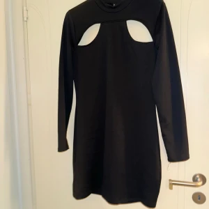 Svart H&M klänning  - Svart medium lång klänning med två öppningar på överdelen i storleken L 