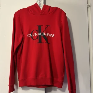 Calvin Klein hoodie  - Röd Calvin Klein hoodie, sparsamt använd. Mycket fint skick. Storlek 16 år (barnstorlek) men passar XS/S.