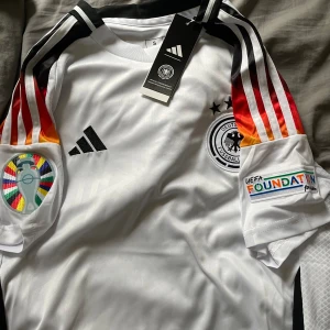 Em Tyskland  - Helt ny, aldrig använd Tyskland tröja. Säljer den då jag vill ha en annan Em tröja så jag kan tänka mig trade mot en annan Em tröja. Kan tänka mig att gå ner lite i pris vid en snabb affär. Skriv gärna vid frågor. Möts upp i Stockholm eller frakt 