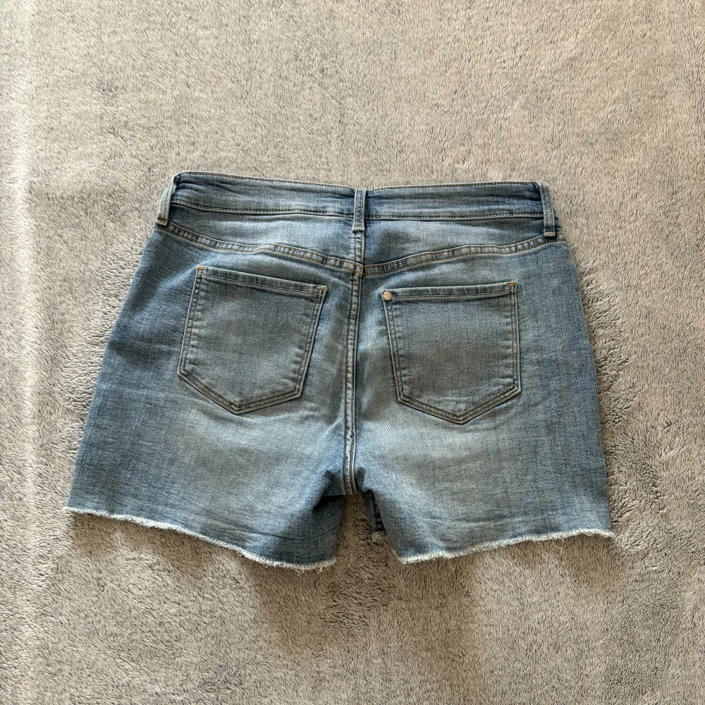 Dessa shorts från H&M är väldigt somriga med färgglada tryck av blommor, fjärilar och nyckelpigor. De sitter inte tajt utan har mycket stretch i sig. Shortsen har knappt varit använda. De är i gott skick utan några defekter.. Shorts.