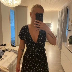 Klänning - Fin blommig klänning, finns ett spänne innanför. Lite urringad men går att sätta en säkerhetsnål om man vill. Lapp bortklippt så vet inte vart den är ifrån.