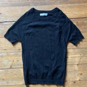 Svart tröja från MNG - En enkel och stilren svart tröja från MNG. Tröjan har korta ärmar och en rund halsringning. Den är tillverkad i ett mjukt material som är bekväm att bära. Skicka dm vid frågor.