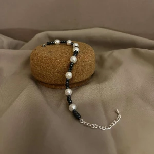 Armband - Cleo - Vårt armband Cleo är gjort i en unik pärldesign med vita stora pärlor och små mörkblåa pärlor. Armbandet har även ett lås och kedja i silver.  Namn: Cleo Längd: Hela 24 cm, Pärlor 16 cm