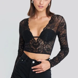 Spetstopp  - Spetstopp från NA-KD Party i storlek L. Svarta vadderingar framtill och bara spets i bak, croppad modell.  Aldrig använd. 