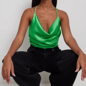 Topp i satin - Snygg grön topp i satin från NA-KD. Oanvänd med prislapp kvar.