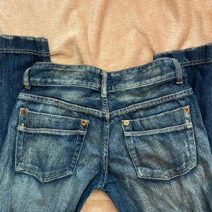 lågmidjade bootcut jeans  - säljer mina snygga lågmidjade jeans som är köpte här på plick, bilderna är även tagna ifrån förra ägaren men om ni vill ha fler bilder så skriv privat. Har lagt in ett snöre i midjan så man kan få dem mindre😇Priset kan även diskuteras  