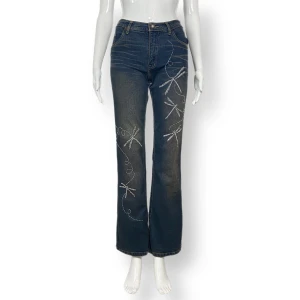 Jeans  - Fina jeans, storlek 27? Jeansen slutar precis under naveln. Made in Thailand. Passar dockan som använder storlek XS. 100% bomull. Midjemått 33cm, skrevdjup 23cm, höftbredd 42cm & innerbenslängd 78cm