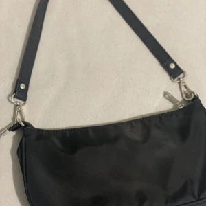 Väska - En svart väska man har över axeln, använt 1 gång