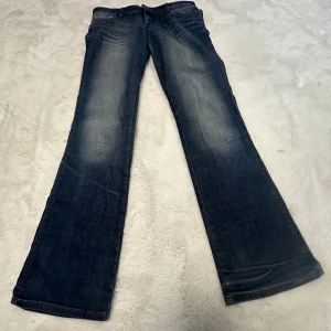 Lågmidjade  Jeans  - Säljer ett par Lågmidjade jeans från märket Wrangler💙💙 Väldigt fin Wash.     Mått: midja 39/40 cm, innerbenslängd 84/85cm  Skriv vid frågor! 🥰 