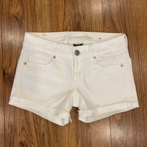 Lågmidjade jeansshorts - Vita lågmidjade jeansshorts med brodering på backfickorna från American Eagle🤍 står storlek 0 i dem, passar en 34/36. Nyskick!! 