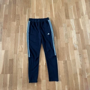 Adidas byxor - Adidas byxor. Dragkedja nere vid benet. Storlek 13-14y. Även snörning i midjan. 