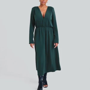 Mörkgrön klänning - BikBok - Oanvänd ankellång satin klänning från BikBok med etikettet på. Köpt för 699kr helt oanvänd säljer för mycket billigt, då den är slutsåld och går ej att returnera. Priset kan diskuteras🫶🏼 