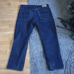 Mörkblåa mcgordon jeans - Mörkblåa jeans som sitter ganska baggy på mig. De är stora i midjan men det funkar bra med bälte. De är använda ganska lite så de är i bra skick.