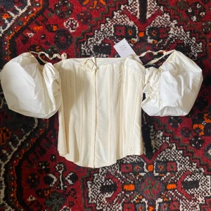 korsett med puffärmar  - off white korsett från noanoa, lite gulnad men är ny med prislapp! står onesize men skulle uppskatta den som en s.